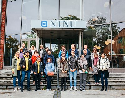 Skupinska slika udeležencev študijskega obiska pred vhodov v stavbo univerze NTNU.