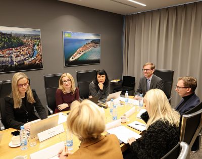 Udeleženci strokovnega posveta sedijo za mizo in sestankujejo.