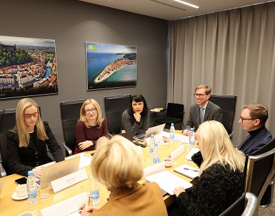 Udeleženci strokovnega posveta sedijo za mizo in sestankujejo.