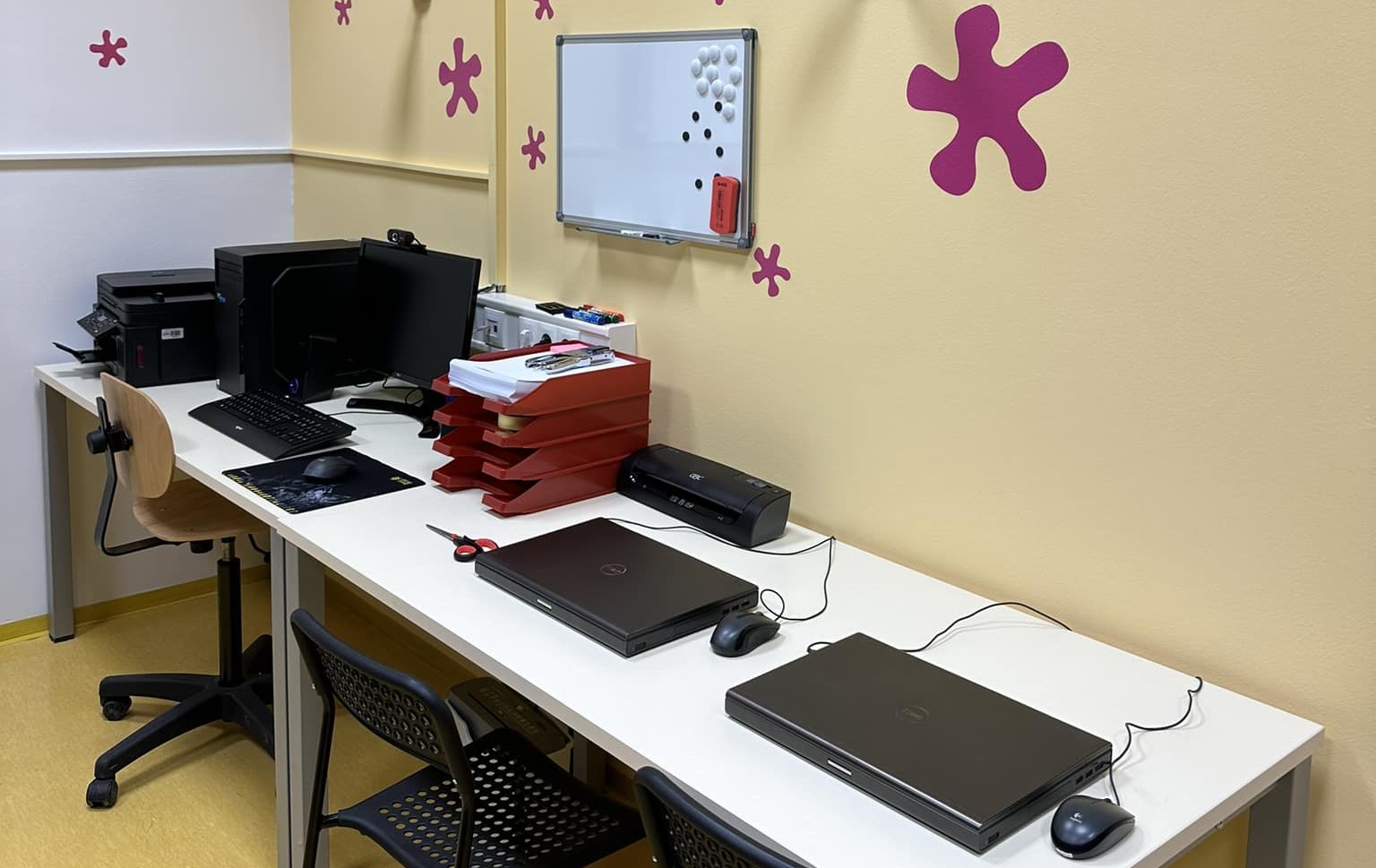desk with two laptops, a multifunction device and office supplies