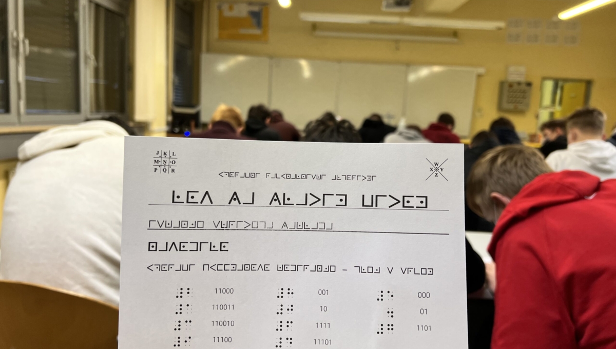 A sheet of paper in front of a classroom full of students.