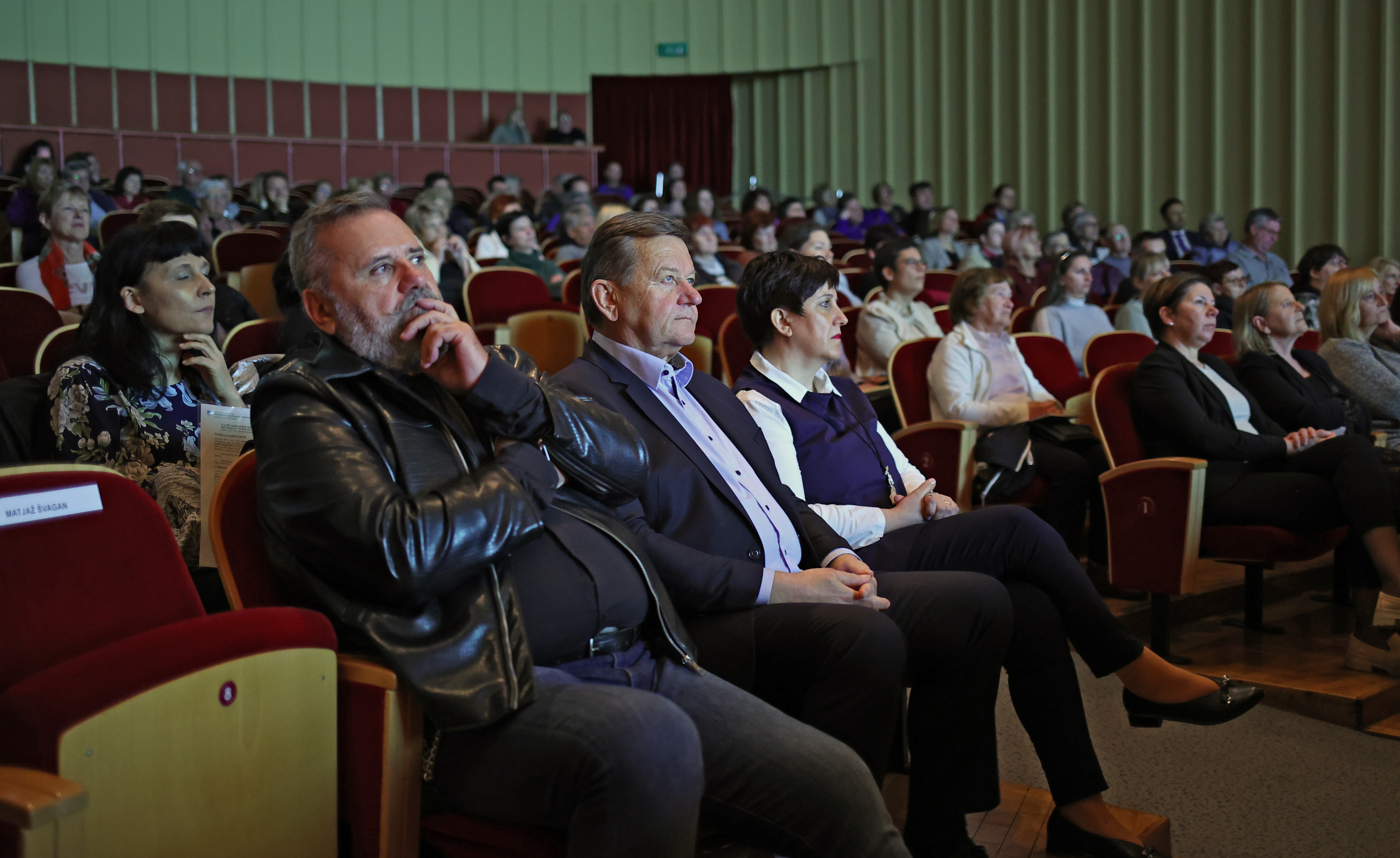 The audience is seated in the auditorium.