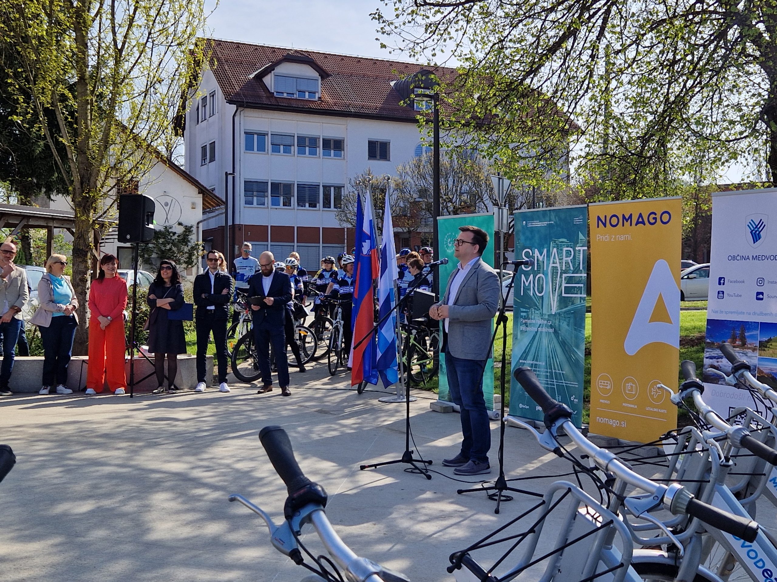 Župan občine Medvode med govorom, ob strani stojijo udeleženci, ki spremljajo dogajanje.