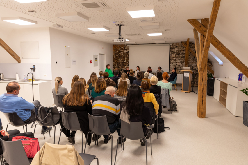 The audience sits and watches the panellists.